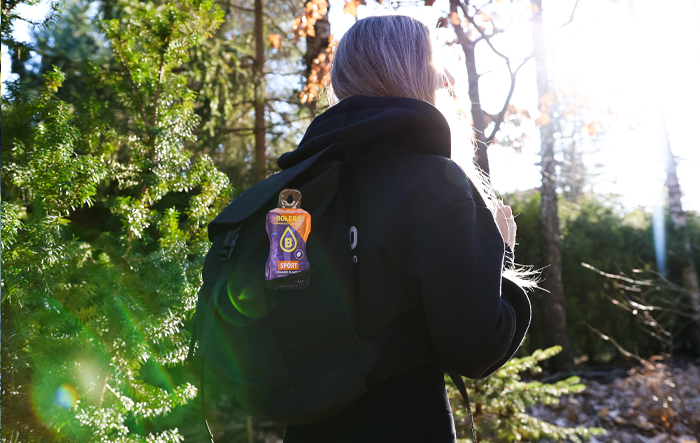 Saszetka Bolero Sport przypięta do plecaka podczas aktywnego spaceru w lesie