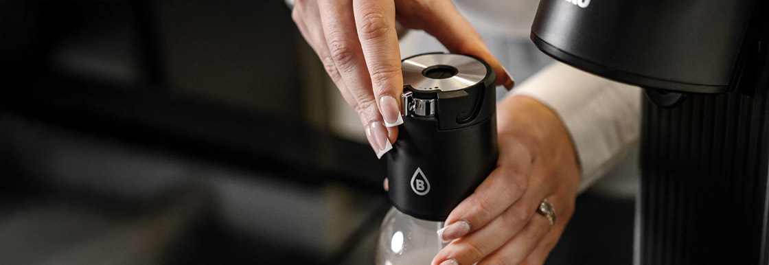 Odkręcanie głowicy saturatora Bolero Soda Maker po zakończonym procesie gazowania.