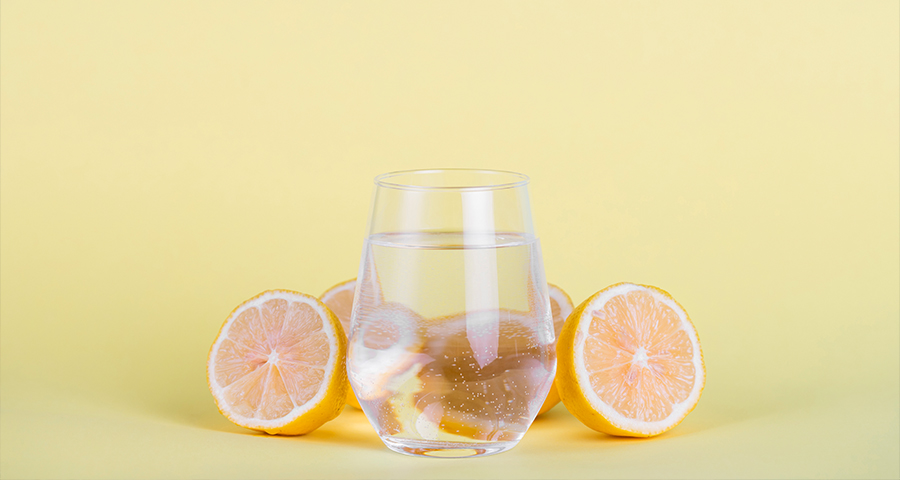 Szklanka wody z plasterkami cytryny – popularny sposób na urozmaicenie picia wody