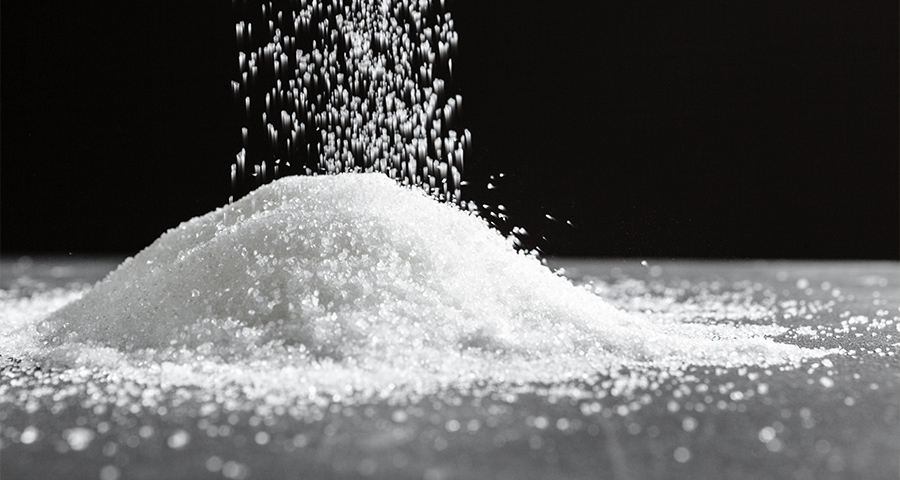 Kobieta w biurze pije wodę i zastanawia się, dlaczego ciągle chce jej się pić