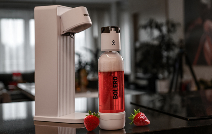 Saturator Bolero z butelką napoju i świeżymi truskawkami w kuchni