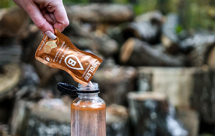 Budzik pokazujący nocną godzinę, w tle rozmyta sylwetka kobiety w łóżku