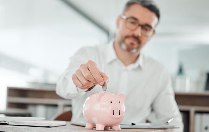 Zbliżenie szklanki wody w rękach kobiety w kuchni, obok świeżych owoc&oacute;w